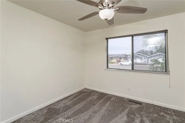 an empty room with a window and wooden floor