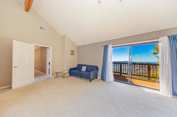 a view of a house with wooden deck and furniture