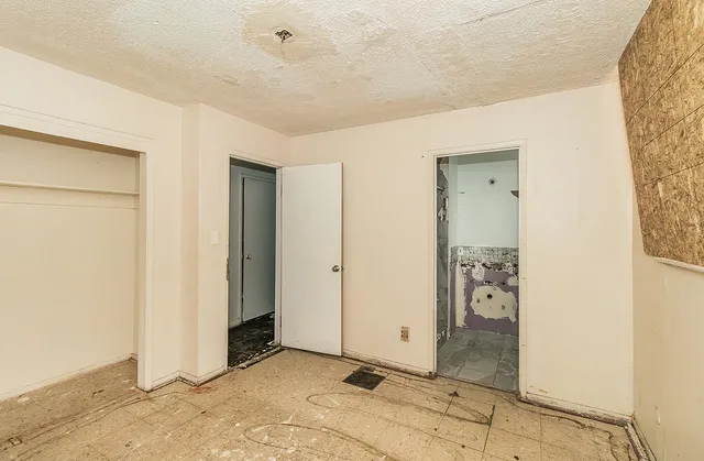 an empty room with a ceiling fan and a window
