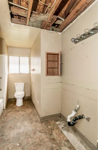 an empty room with wooden floor and a ceiling fan