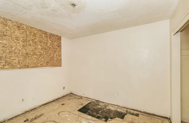 a view of a livingroom with wooden floor and a bathroom