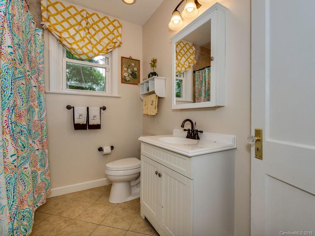 2174 Colony Road Charlotte, NC 28209 - Photo 16 of 24 a bathroom with a granite countertop sink a toilet and a mirror