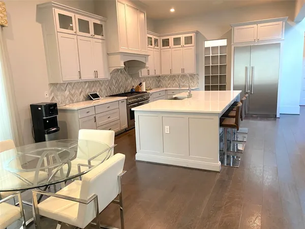 a kitchen with a dining table chairs and white cabinets