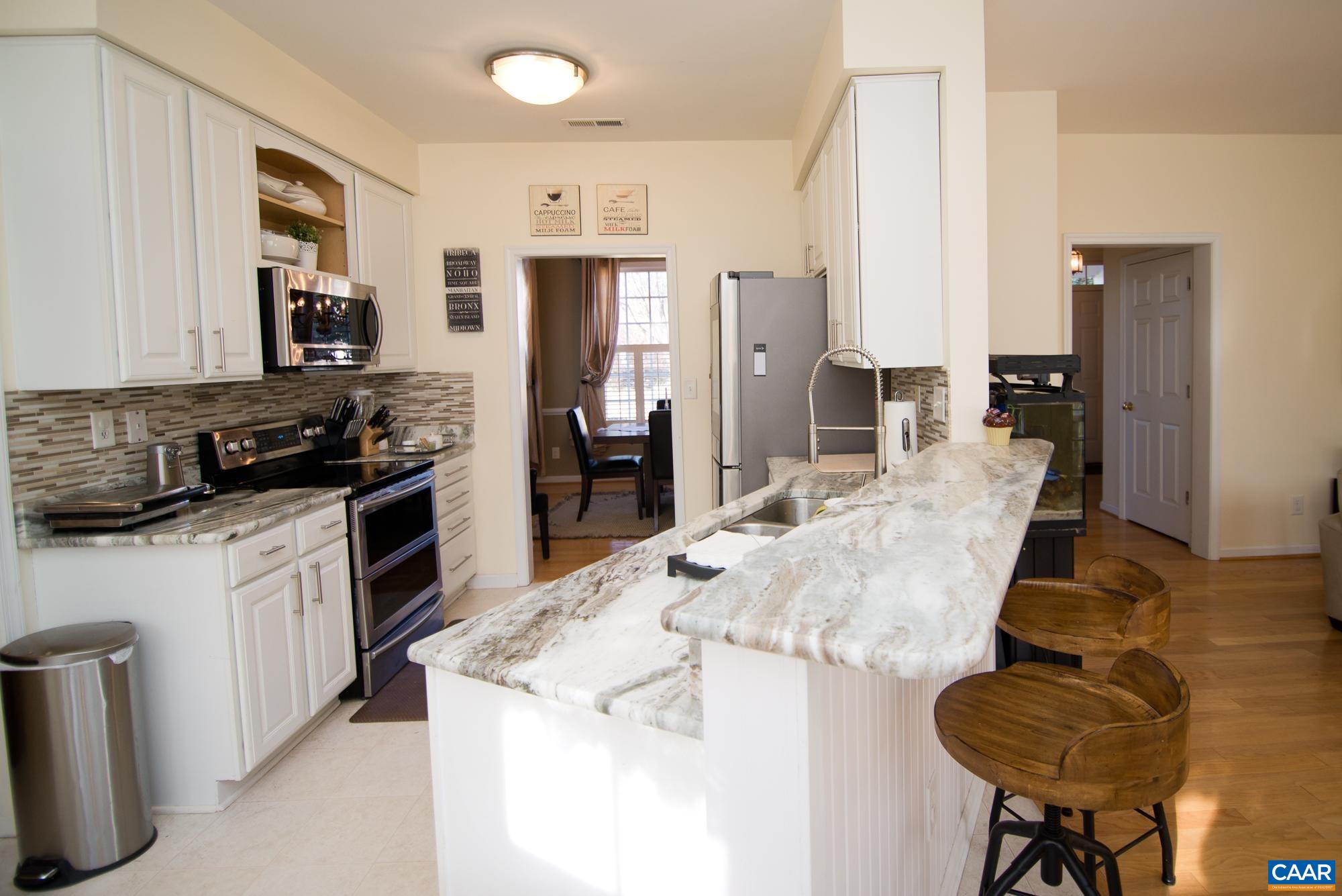 2986 Magnolia Bend Charlottesville, VA 22911 - Photo 11 of 22 a kitchen with stainless steel appliances kitchen island granite countertop a refrigerator and a sink