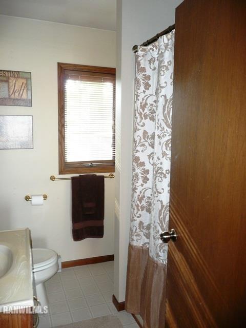 12982 North Bluff Road Baileyville, IL 61007 - Photo 15 of 25 a bathroom with a toilet and a shower curtain