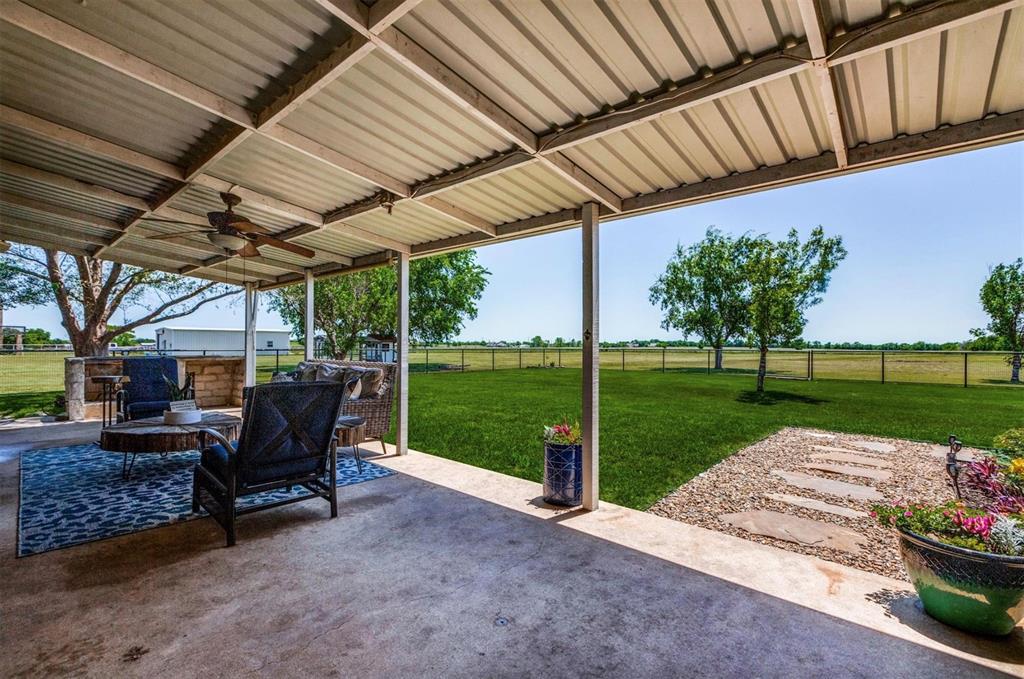 1992 Bledsoe Road Gunter, TX 75058 - Photo 24 of 40 a view of a patio with table and chairs potted plants with wooden floor and fence