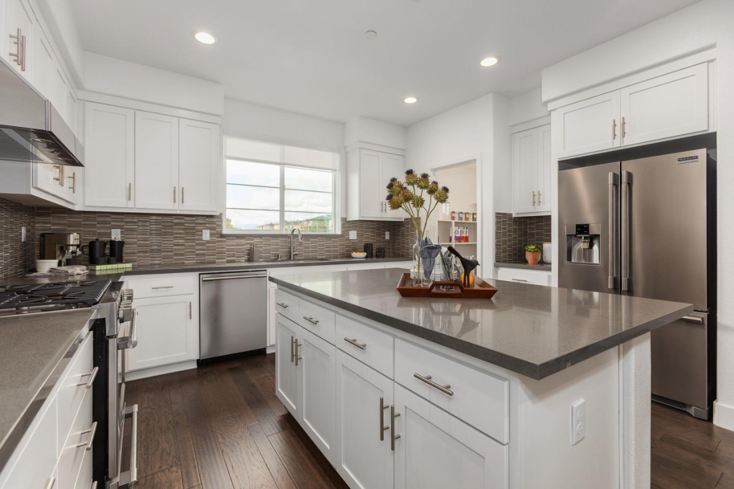 142 Cue Way Hayward, CA 94544 - Photo 10 of 24 a kitchen with stainless steel appliances granite countertop a sink dishwasher a refrigerator and white cabinets with wooden floor