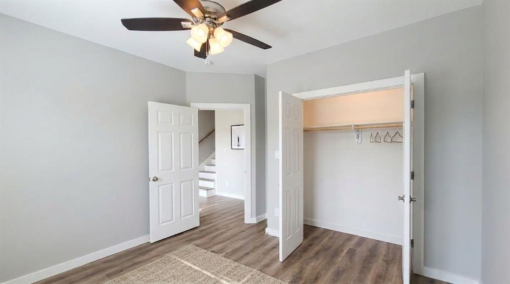 9114 Caddo Road, Unit A & B Houston, TX 77078 - Photo 7 of 24 Bedroom 1 - Downstairs Virtually Staged Spacious room featuring vinyl flooring, light gray walls, white trim, a ceiling fan with integrated lighting, and a closet with bifold doors