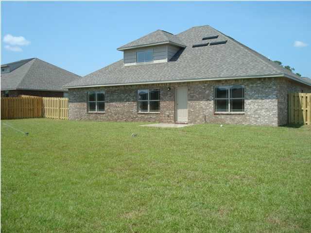 5252 Moore Loop Crestview, FL 32536 - Photo 2 of 28 a front view of house with yard and trees in the background