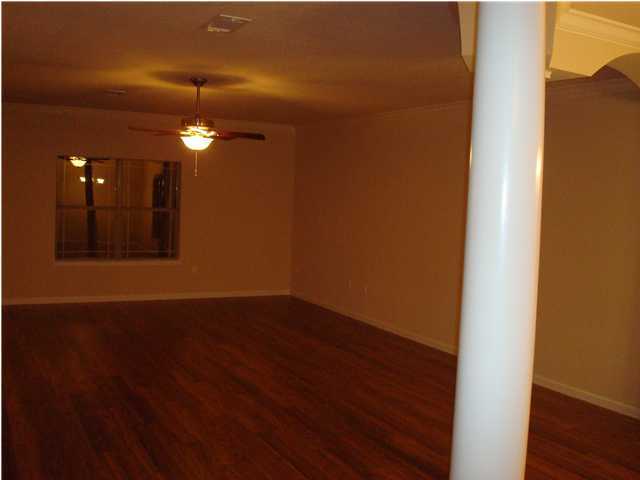 5252 Moore Loop Crestview, FL 32536 - Photo 10 of 28 a view of an empty room with wooden floor and fan