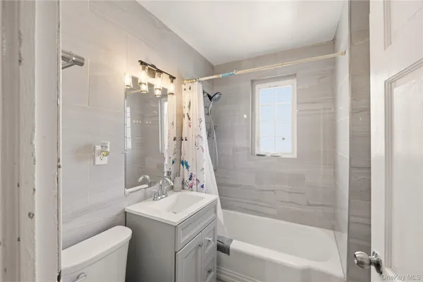 a bathroom with a sink mirror toilet and bathtub