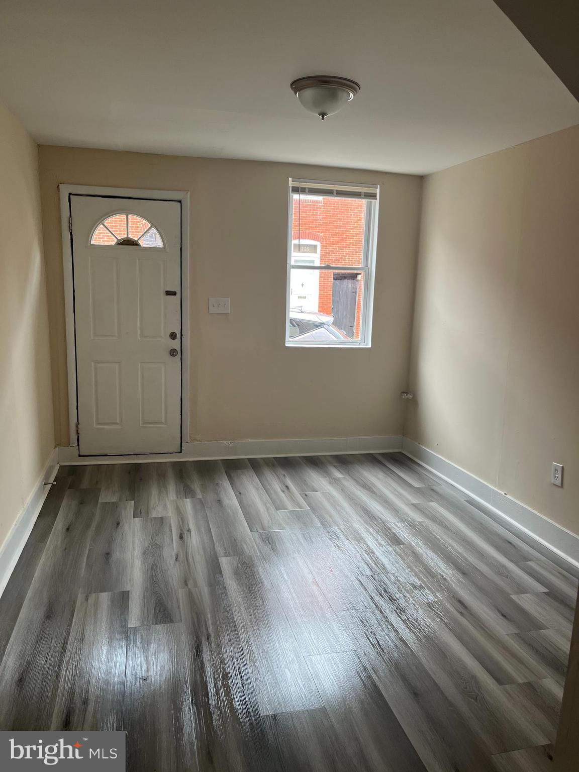 226 South Regester Street Baltimore, MD 21231 - Photo 5 of 17 an empty room with wooden floor and windows