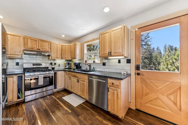 a kitchen with stainless steel appliances granite countertop a stove a sink and a microwave