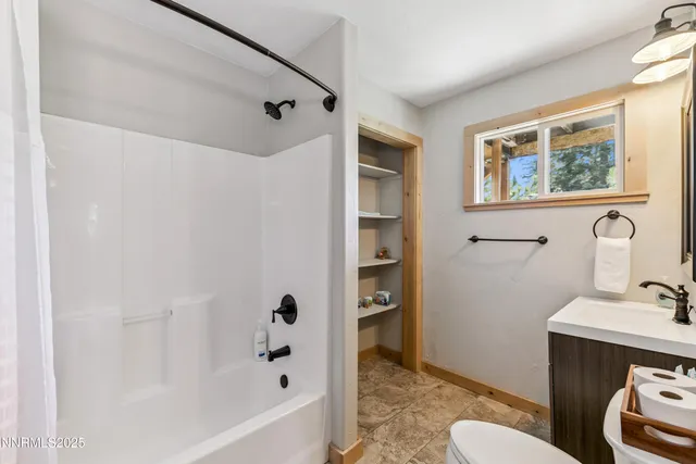 a bathroom with a bathtub sink mirror vanity and toilet