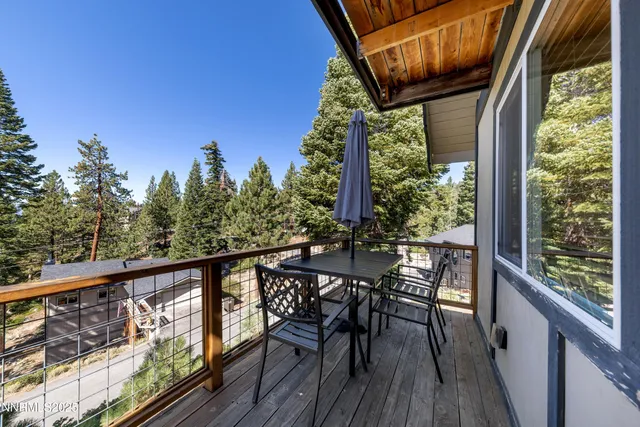 a view of a wooden chairs and table in the balcony