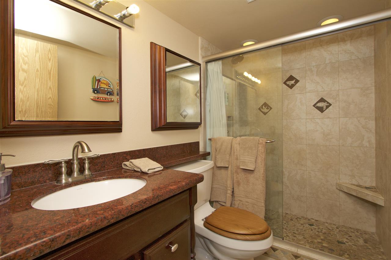 2219 South Kihei Road, Unit B102 Kihei, HI 96753 - Photo 13 of 30 a bathroom with a granite countertop sink toilet a mirror a vanity and shower