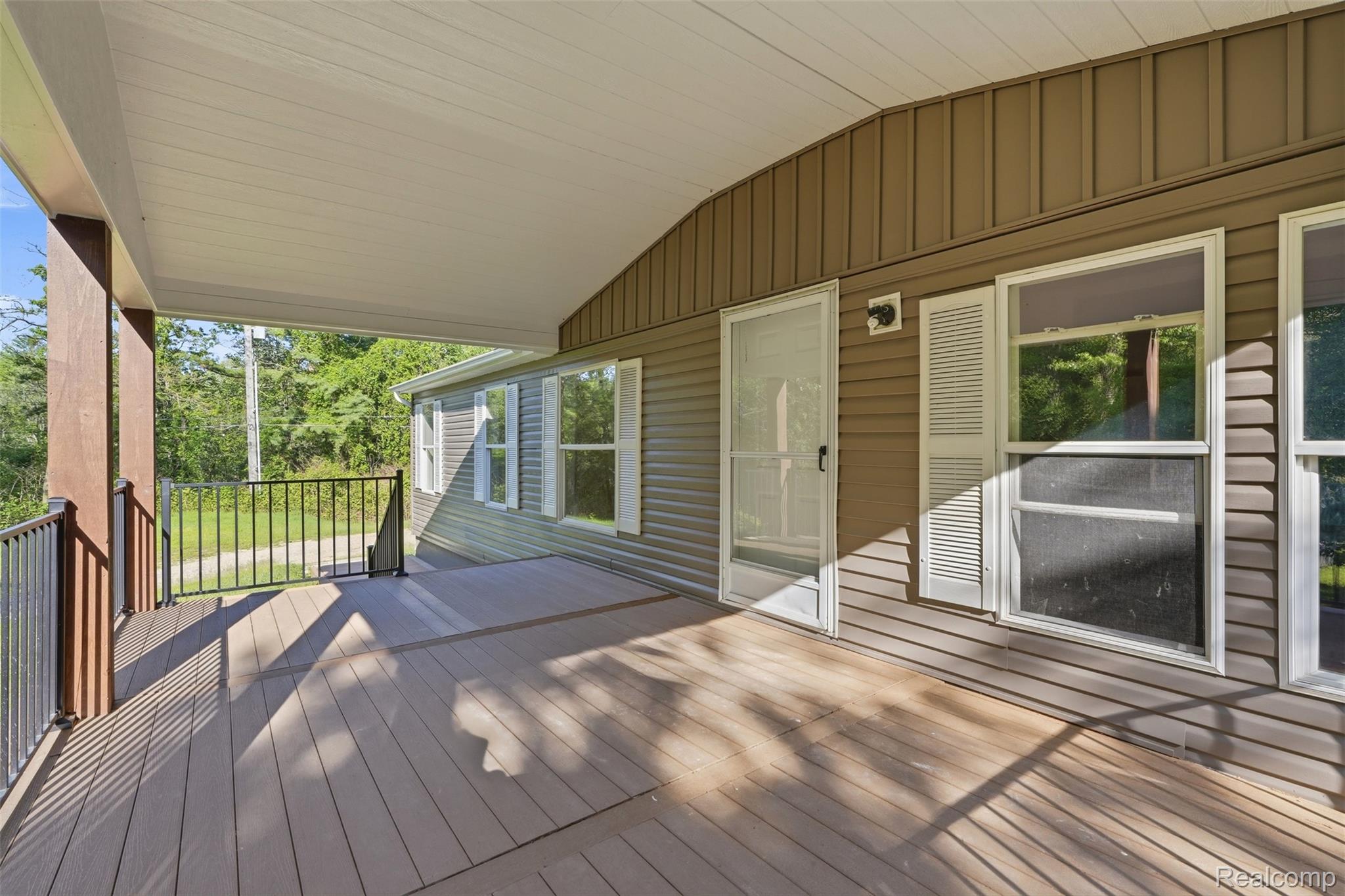 3432 Stanton Road Oxford, MI 48371 - Photo 6 of 48 Expansive covered porch featuring composite decking and black metal railings