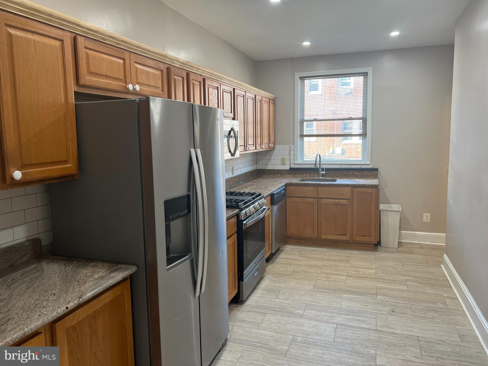 3340 Cottman Avenue Philadelphia, PA 19149 - Photo 2 of 42 a kitchen with stainless steel appliances granite countertop a refrigerator a sink a stove with wooden cabinets