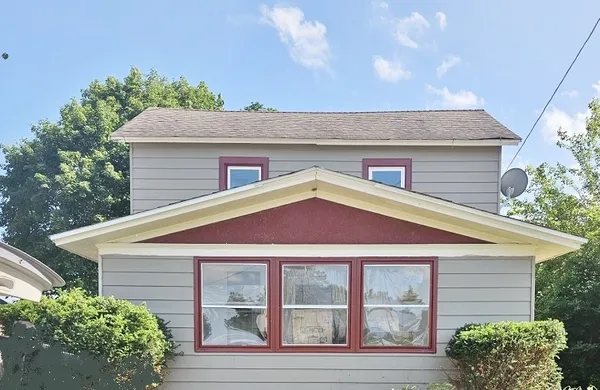 a view of a house with a yard and potted plants