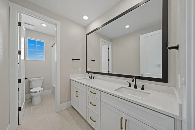 a bathroom with a toilet sink and mirror