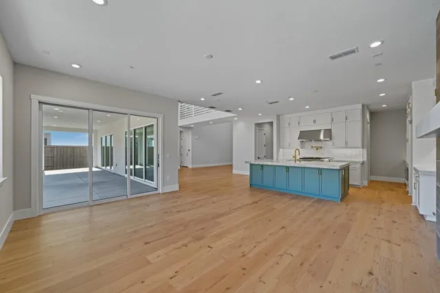 a view of kitchen with kitchen island a sink wooden floor and view living room