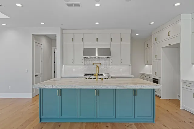 a kitchen with kitchen island a sink stainless steel appliances and cabinets