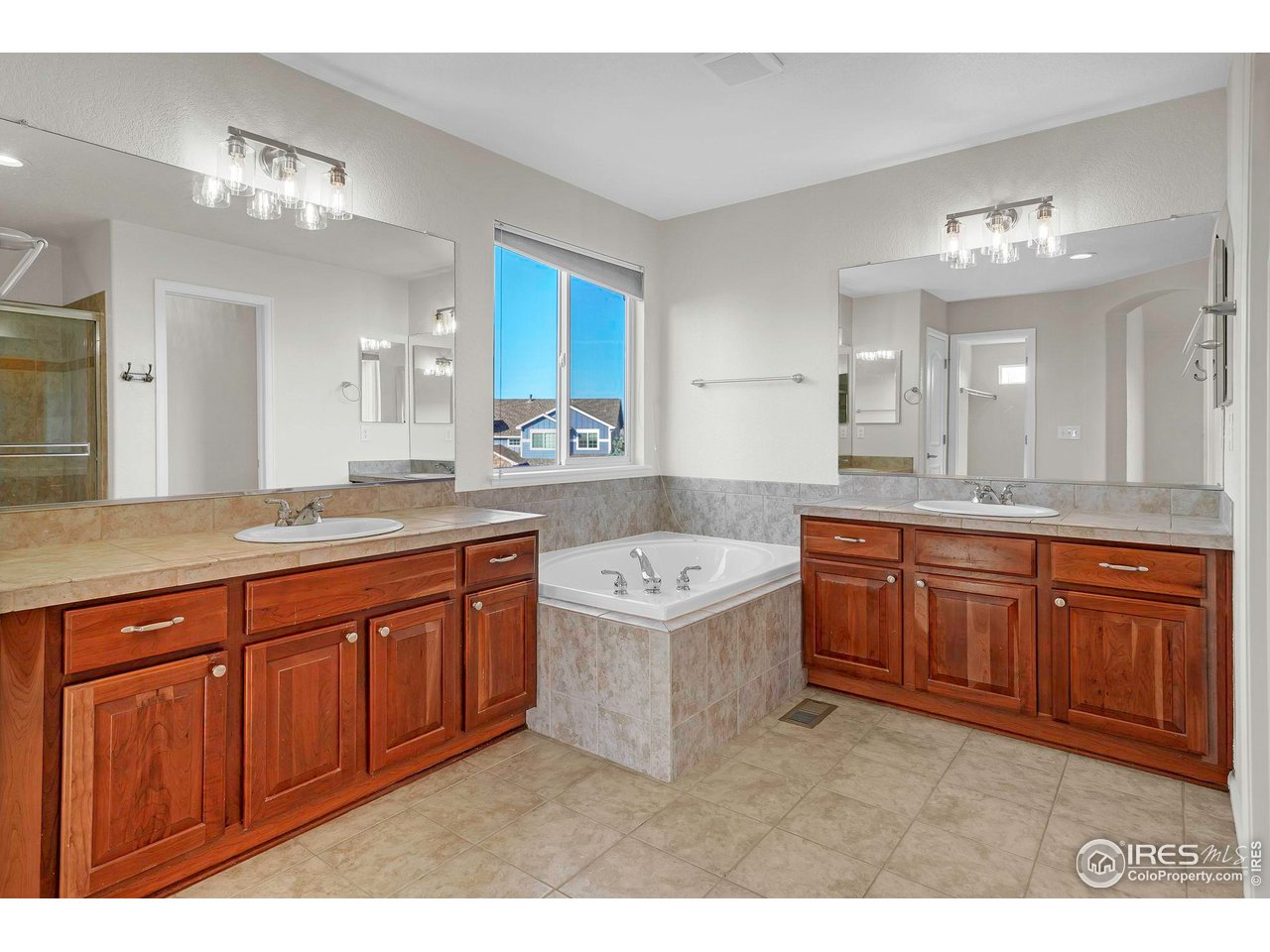 1936 Alpine Drive Erie, CO 80516 - Photo 26 of 47 a spacious bathroom with a granite countertop double vanity sink a mirror and a bathtub