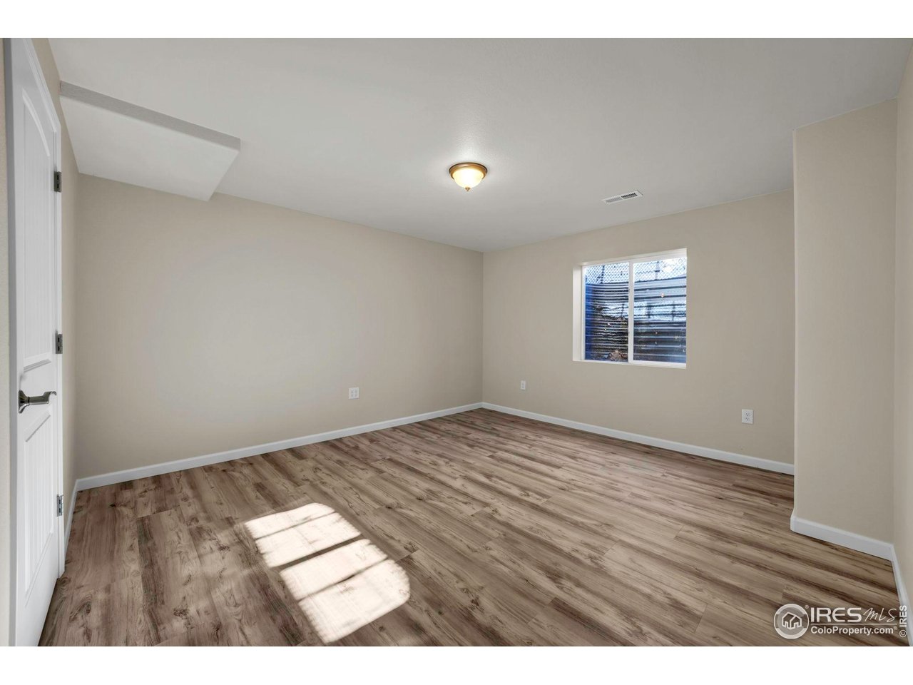 1936 Alpine Drive Erie, CO 80516 - Photo 37 of 47 a view of an empty room with wooden floor and a window