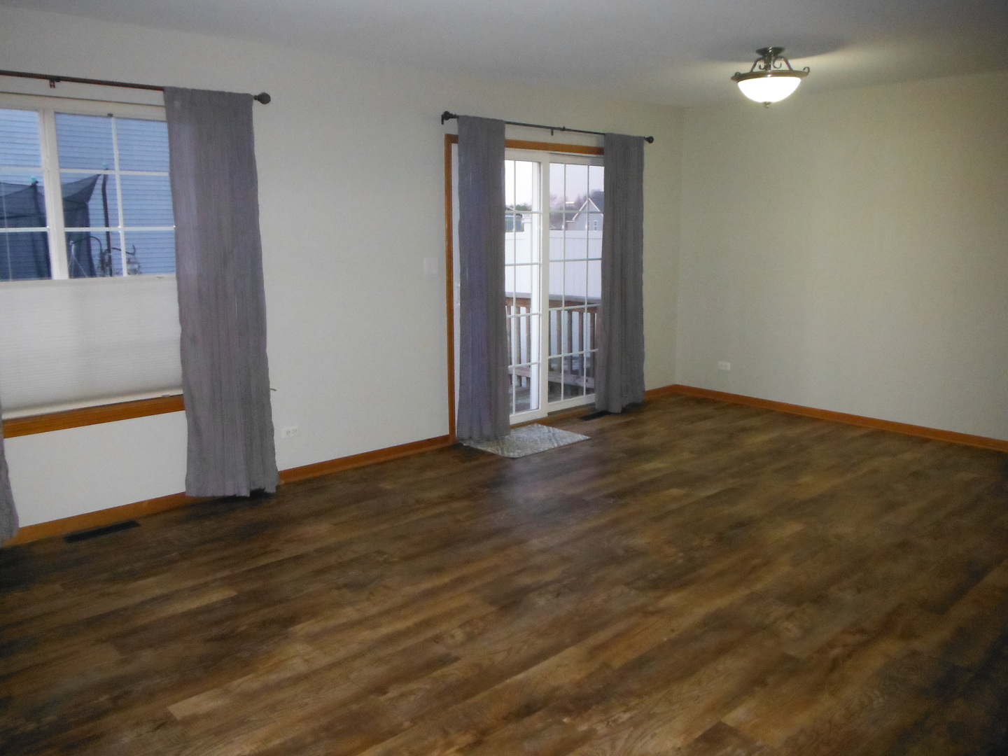 574 Boulder Drive Morris, IL 60450 - Photo 6 of 13 an empty room with wooden floor and windows