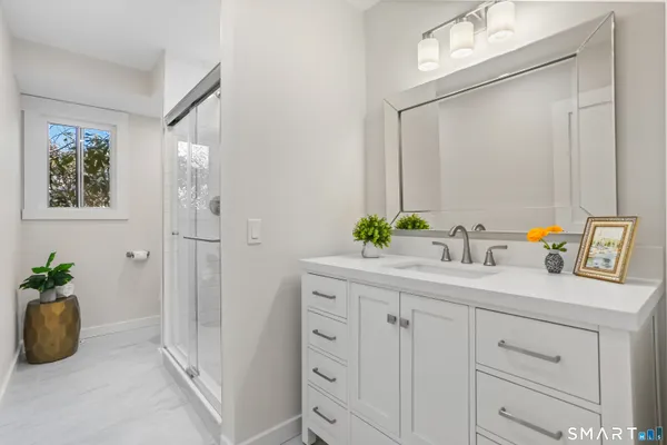 a bathroom with a granite countertop sink a vanity a window and a mirror
