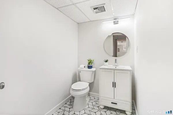a bathroom with a toilet sink and mirror