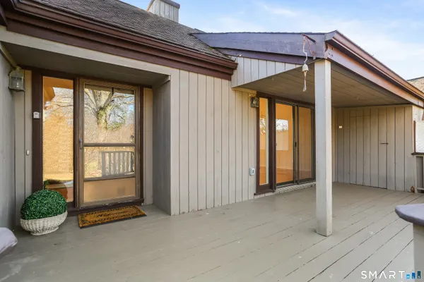 a balcony with wooden floor and trees