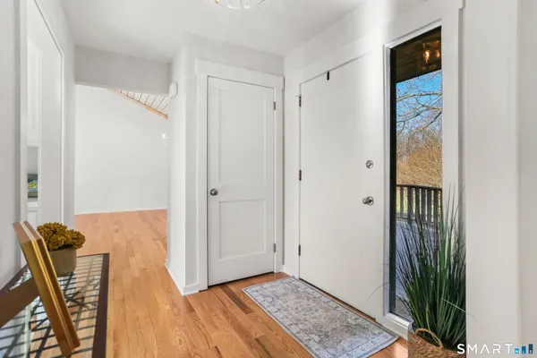 a view of a hallway with wooden floor and stairs