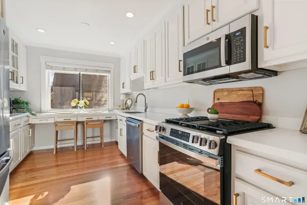 a kitchen with stainless steel appliances a stove a sink and a microwave