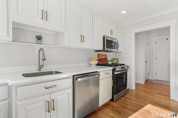 a kitchen with stainless steel appliances granite countertop a sink and a stove top oven