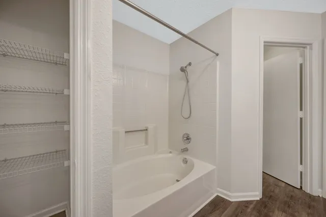 an empty room with chandelier fan and windows