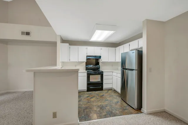 a kitchen with a refrigerator and a stove top oven