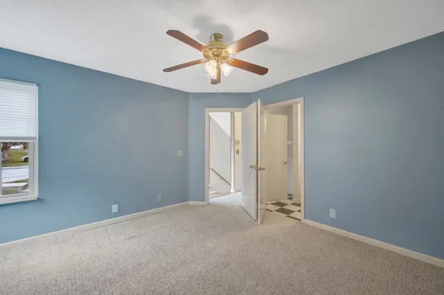 an empty room with closet and ceiling fan