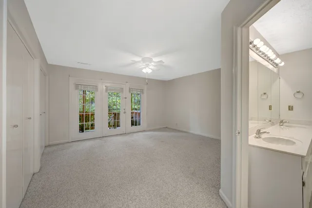 a view of a big room with windows and chandelier fan