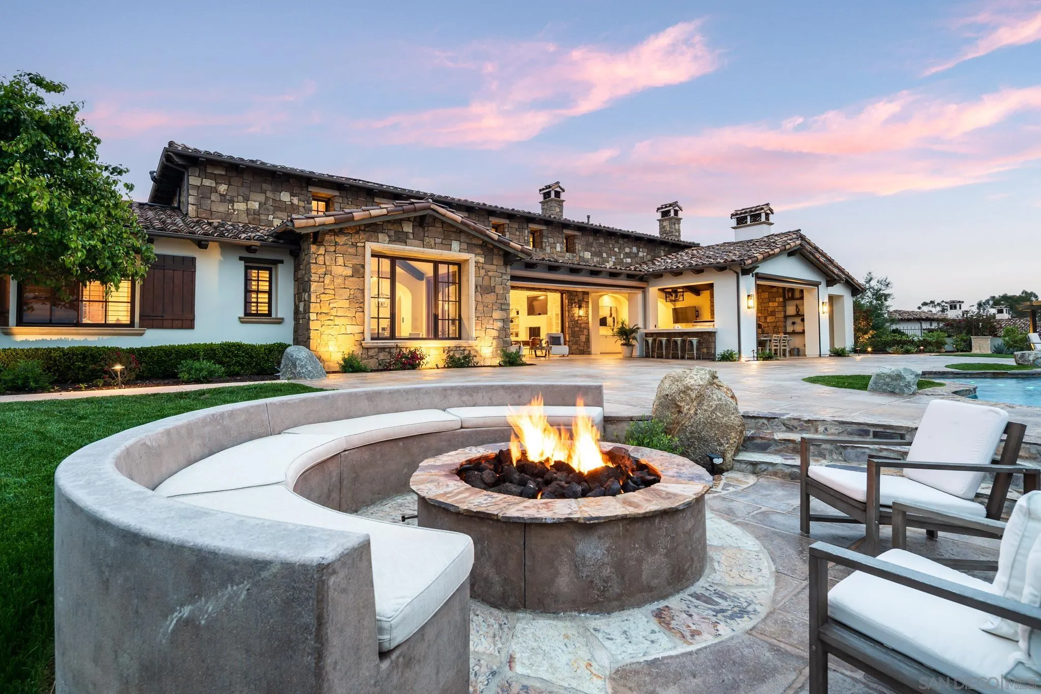 8415 Run Of The Knolls Court San Diego, CA 92127 - Photo 12 of 39 a front view of a house with a yard fountain and a fire pit