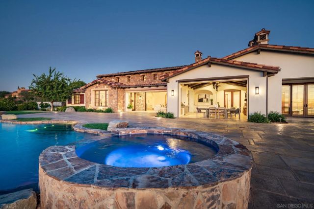 a view of a house with swimming pool and sitting area