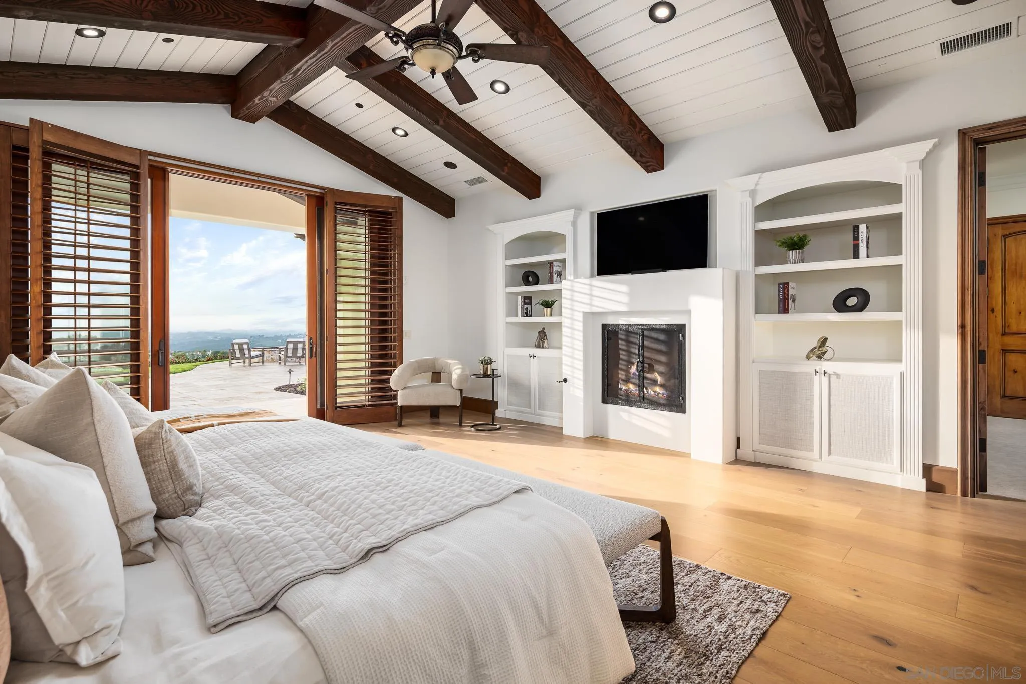 8415 Run Of The Knolls Court San Diego, CA 92127 - Photo 24 of 39 a spacious bedroom with a bed a flat screen tv and a fireplace