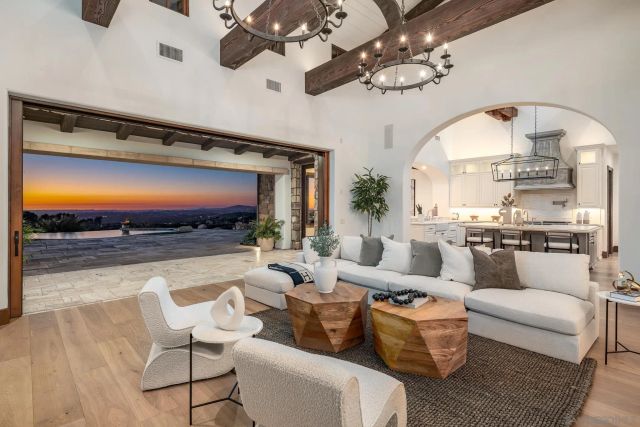 a living room with furniture a chandelier and a flat screen tv