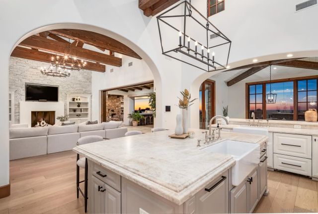 a kitchen with a sink a counter top space and living room view