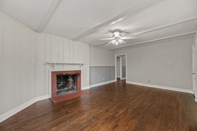 wooden floor fireplace and windows in an empty room