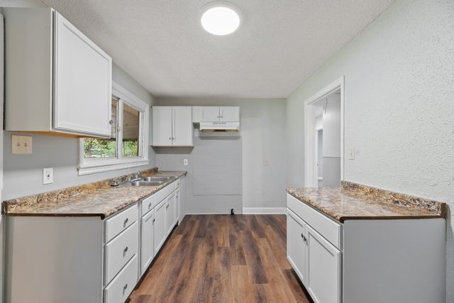 a kitchen with a sink stove top oven and cabinets