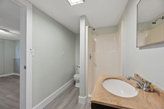 a bathroom with a granite countertop sink mirror vanity and a toilet