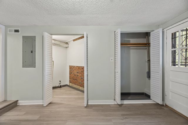 an empty room with windows and closet