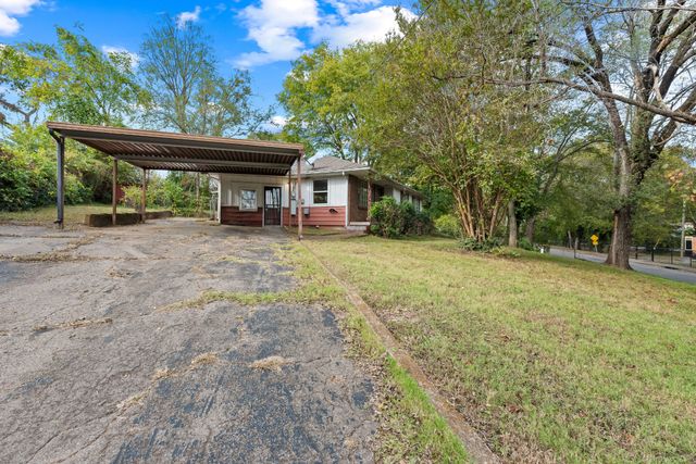 a view of a house with backyard and trees