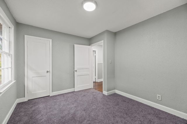 an empty room with windows and closet